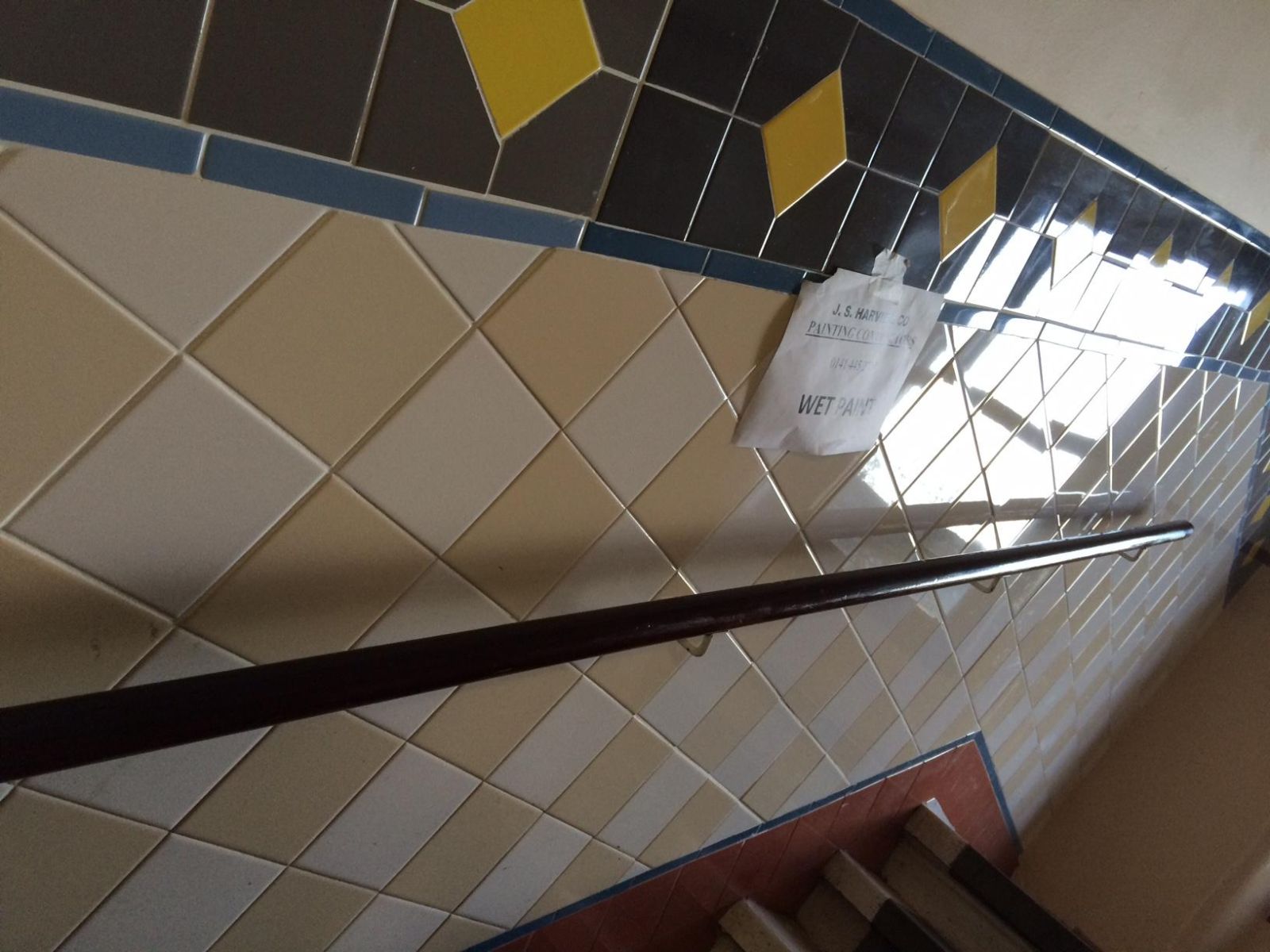 some kitchen tiles with a 'wet paint' sign attached