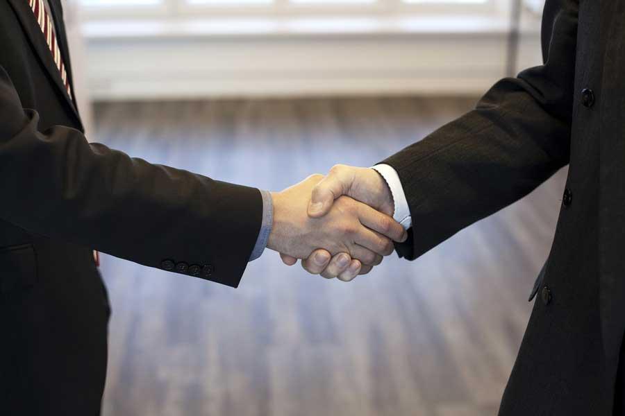 Two men in suits shaking hands